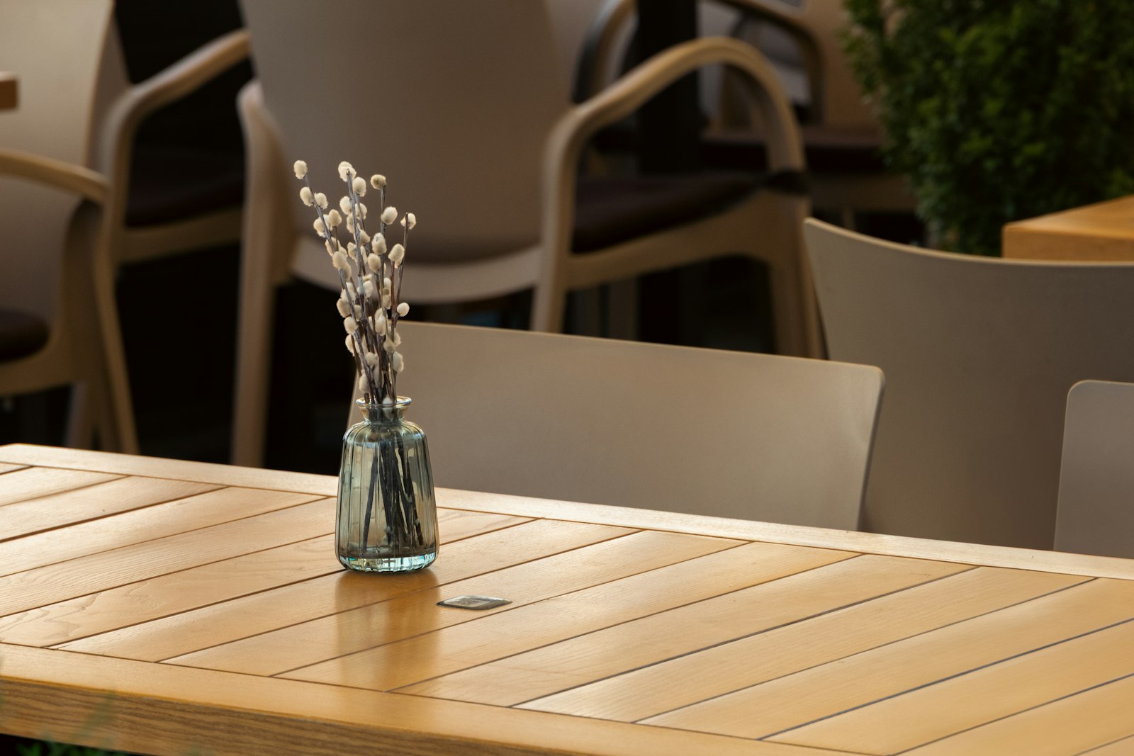 A vase of flowers sits on a wooden table.