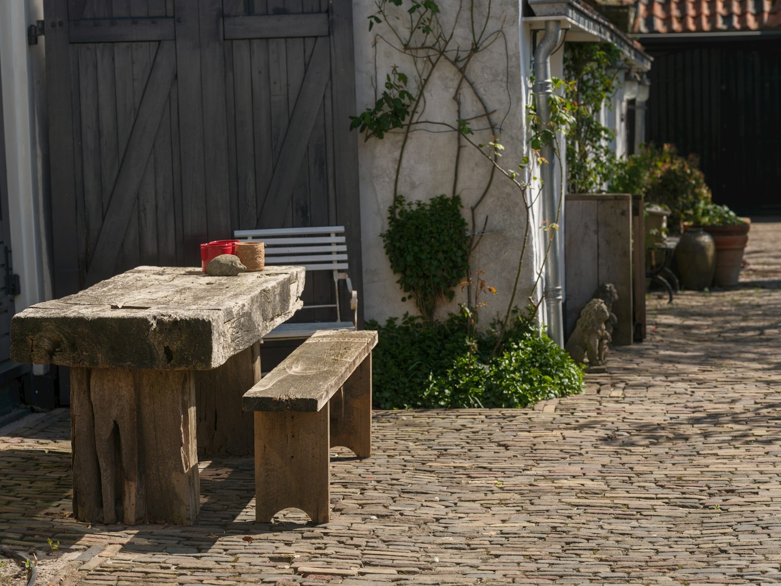 Wooden table and bench outside on a patio.