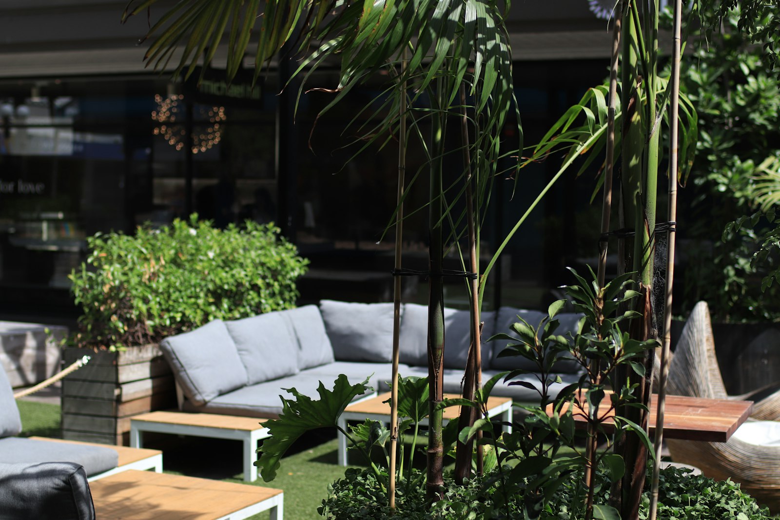 Outdoor lounge area with modern furniture and lush greenery